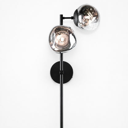 Two-light sconce with irregular smoke glass shades on black rod, white studio background