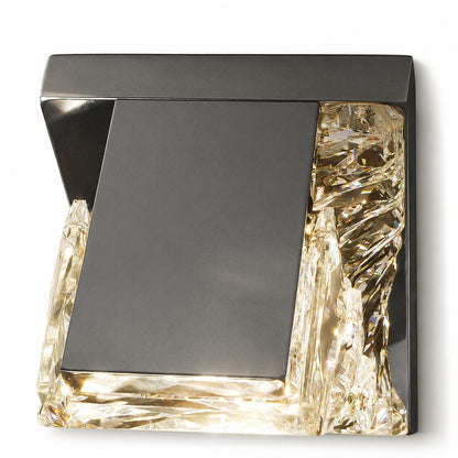Angled overhead view of compact square sconce, dark gunmetal plate framed by lit crystal