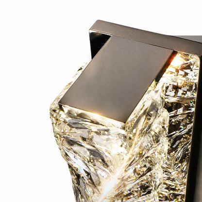 Detail of gunmetal metal cap capping the glowing crystal column at sconce top