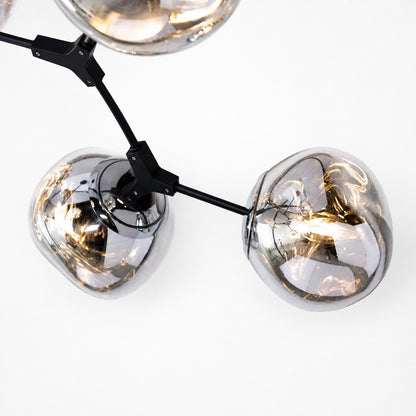 Close-up of matte black arm joints and illuminated reflective acrylic globe shades
